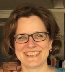 A photo of a smiling Dr Dorothee Hölscher, who has short brown hair and black glasses. 