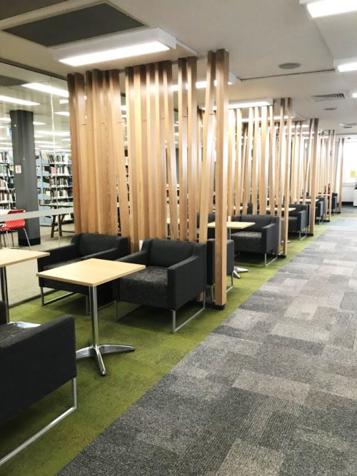 Study tables and chairs separated by stylish timber dividers.