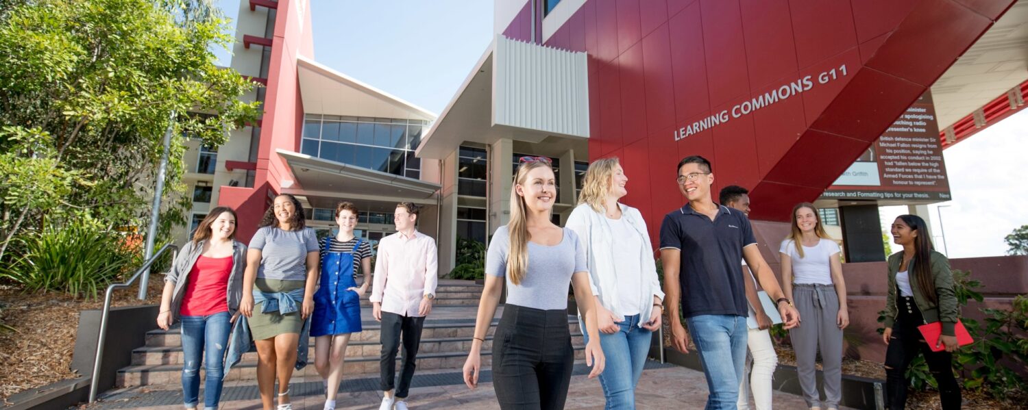 Three groups of students are leaving the Library, walking down the stairs the name of the building in the background reads 'Learning Commons G11'.