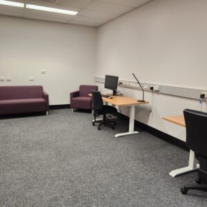 A room with desks, chairs and lounges.